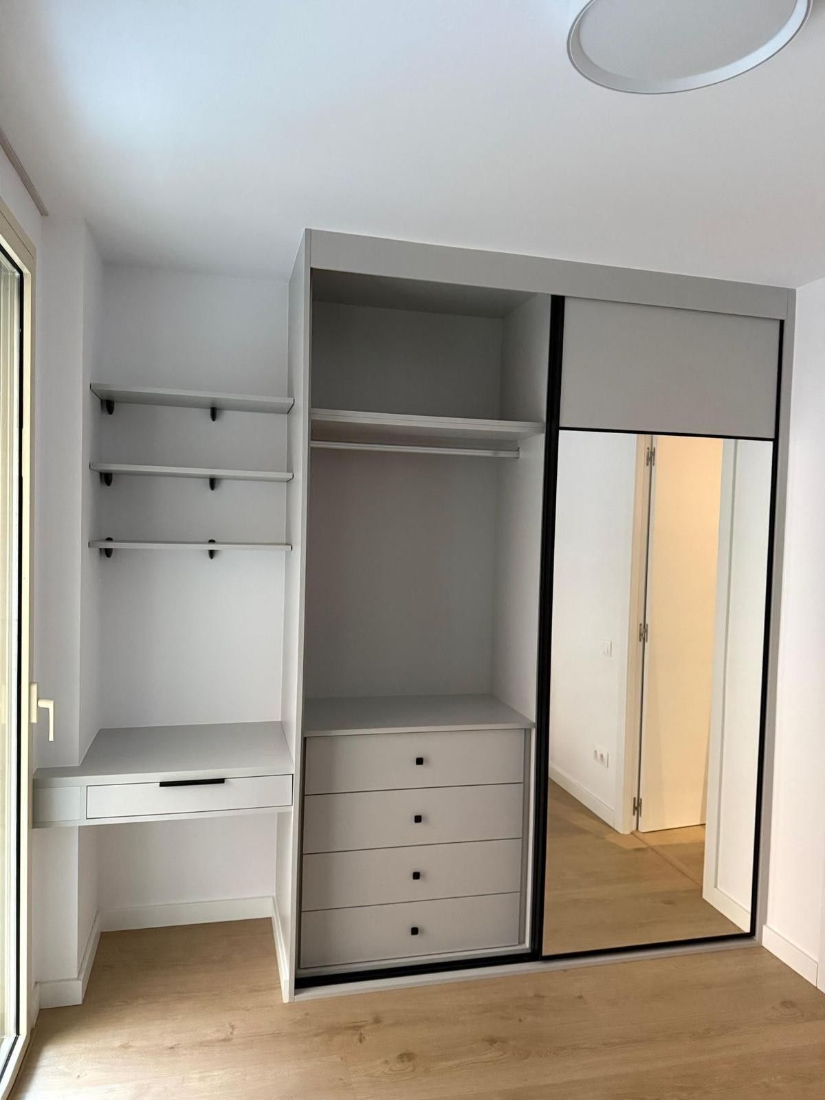 Armario empotrado blanco con estantes, cajones, rincón de escritorio y puertas correderas con espejo