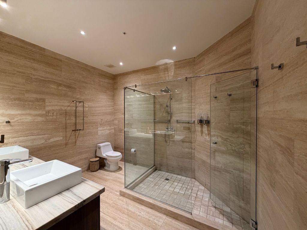 Modern spa-inspired bathroom Playa Escondida. Stone finishes and rain shower for a restorative experience