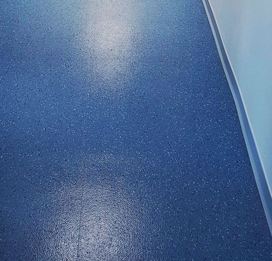 Eine Nahaufnahme eines blauen Bodens mit einer weißen Wand im Hintergrund.