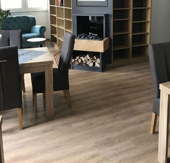 Ein Wohnzimmer mit Tisch und Stühlen und einem Kamin