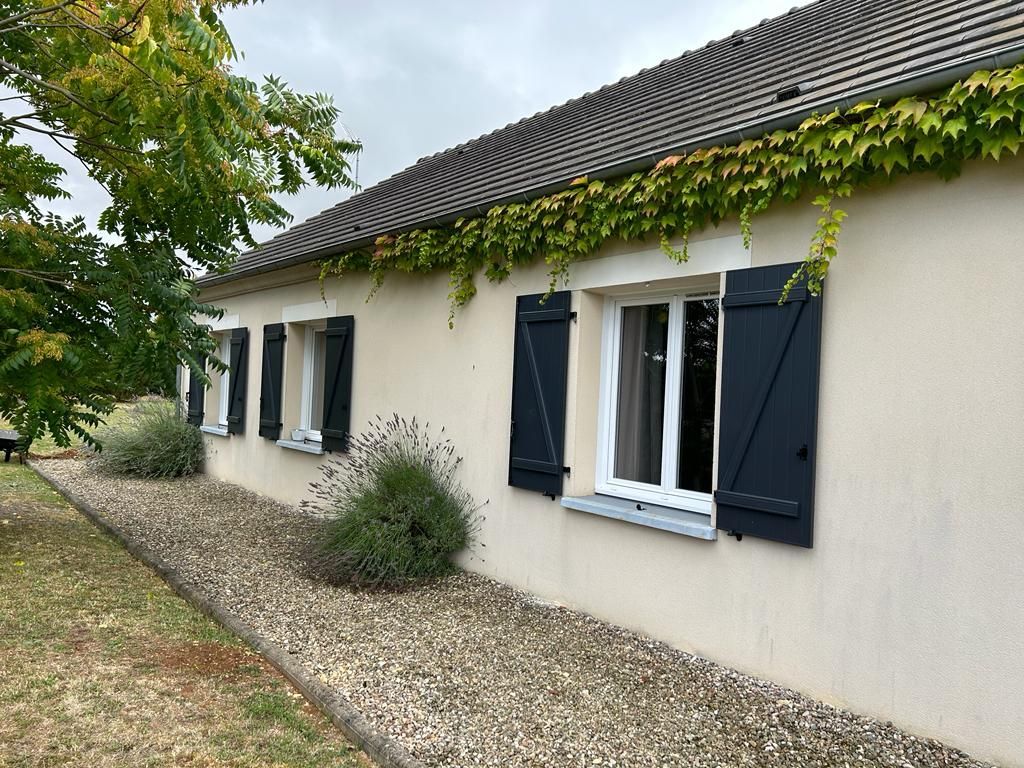 Une maison blanche avec des volets en bois aux fenêtres