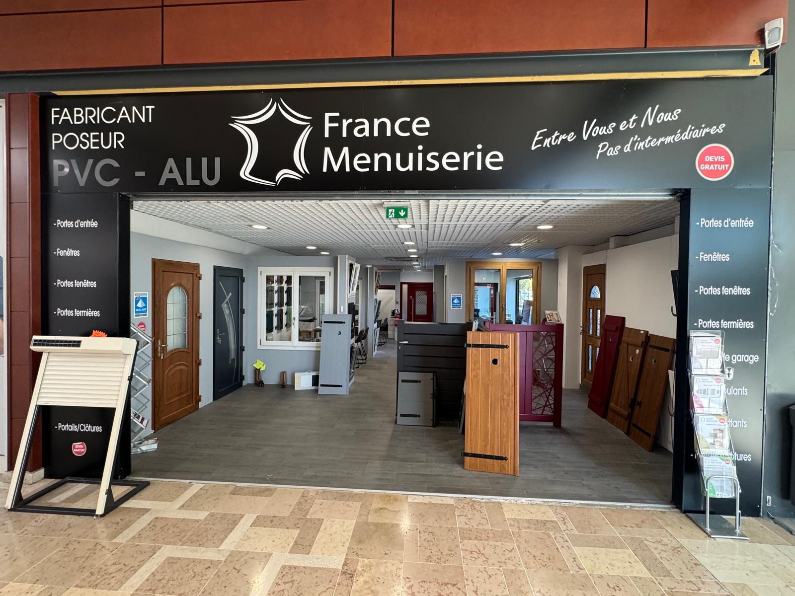 Entrée d'un magasin France Menuiserie, présentant portes et fenêtres.