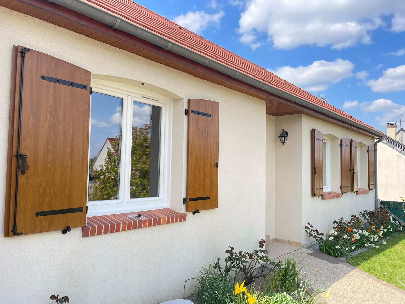Maisonnette avec volets bleus, éléments en brique et jardin. Belle luminosité.