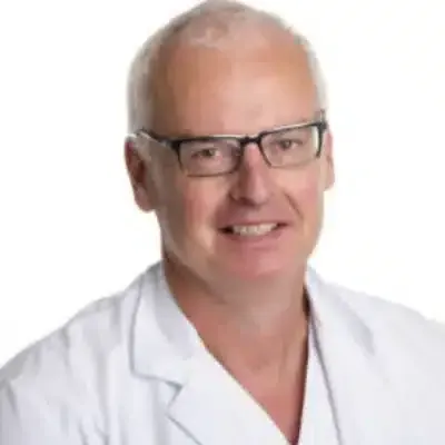 Homme souriant en blouse blanche et lunettes sur fond blanc