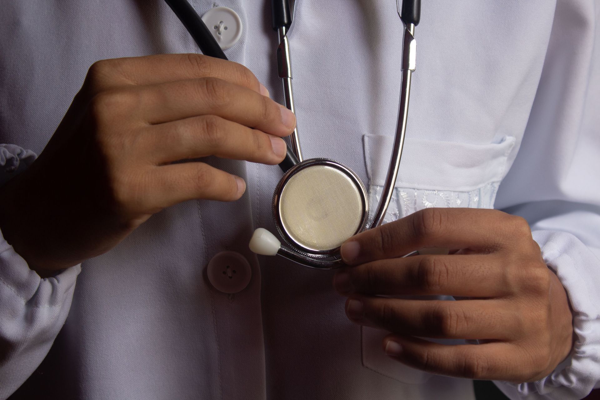 Médecin tenant un stéthoscope contre une blouse blanche
