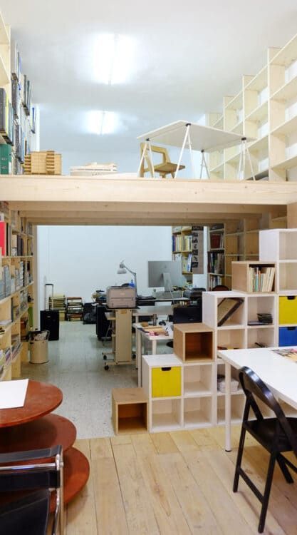 Una habitación con una litera y muchos estantes.