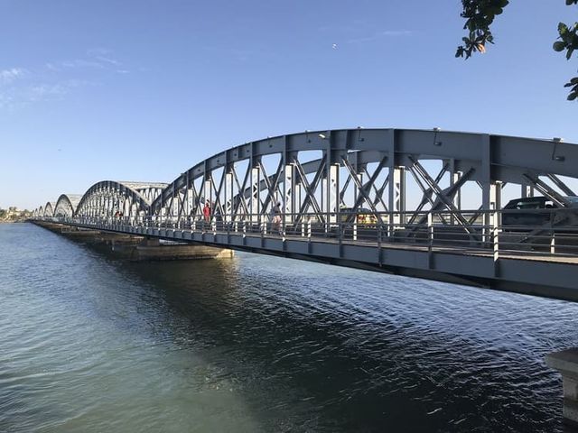 Un puente sobre un cuerpo de agua con un cielo azul de fondo.