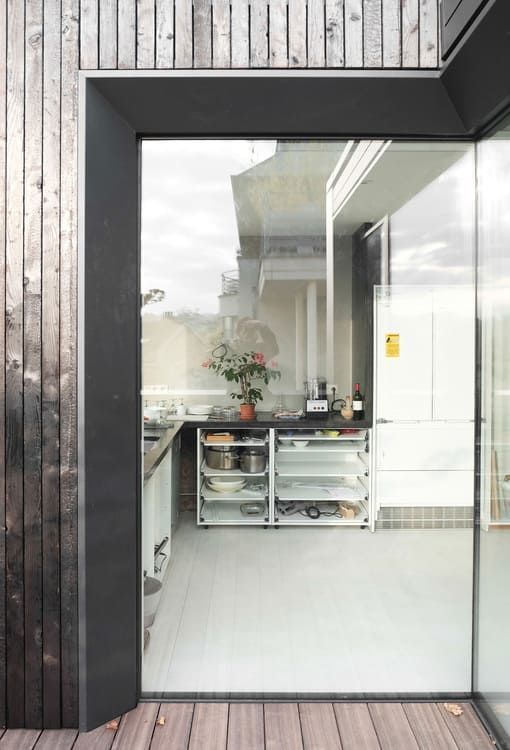 Una vista de una cocina a través de una puerta corrediza de vidrio.