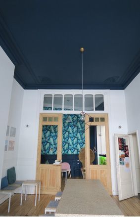 Una habitación con una mesa larga y un techo azul.