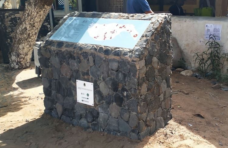 Un gran bloque de piedra con un cartel encima.