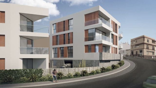 Moderno edificio de apartamentos blanco con persianas de madera en una calle con curvas. Una mujer camina en primer plano.