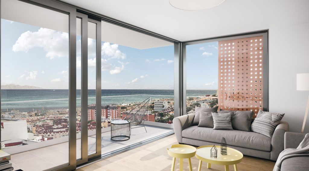 Una sala de estar con un sofá y vista al mar.