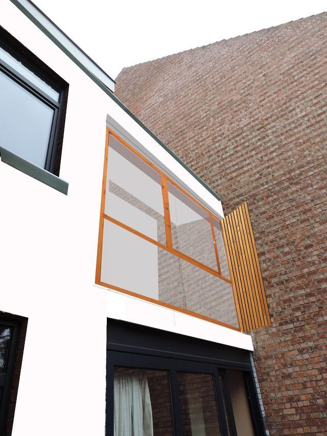 Un edificio blanco con una pared de ladrillos detrás.