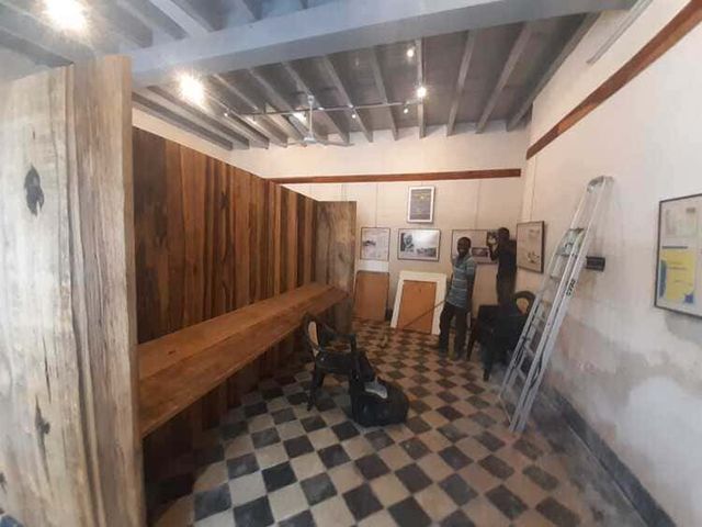 Un grupo de personas está trabajando en una habitación con suelo cuadriculado.