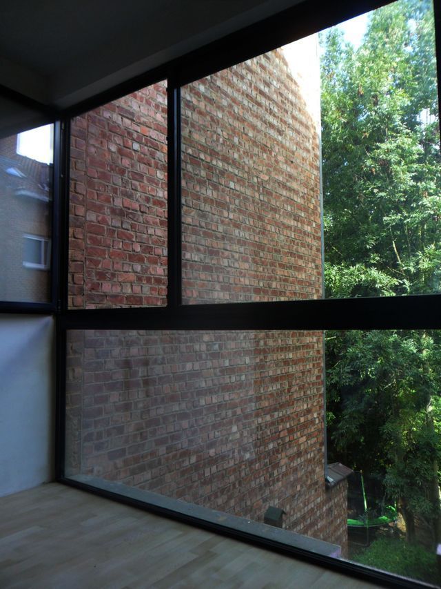 Una habitación con una pared de ladrillo y una ventana grande
