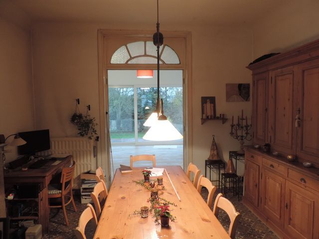 Un comedor con una larga mesa de madera y sillas.