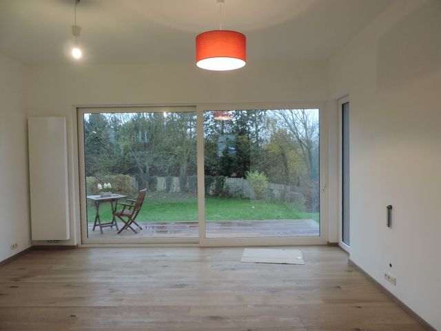 Una habitación vacía con una puerta corrediza de vidrio y una lámpara roja.