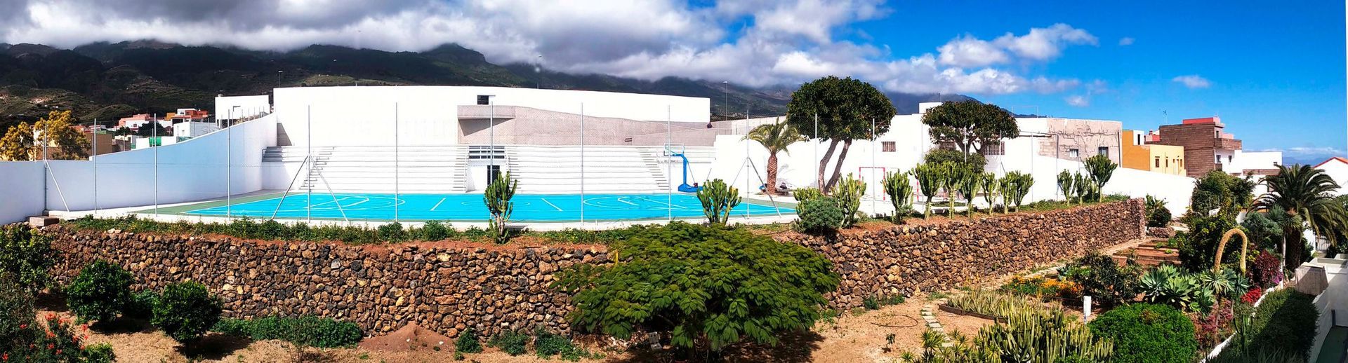 Un gran edificio blanco con una piscina enfrente.