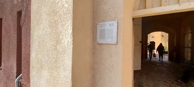 Un cartel en el costado de un edificio muestra el camino hacia un edificio.