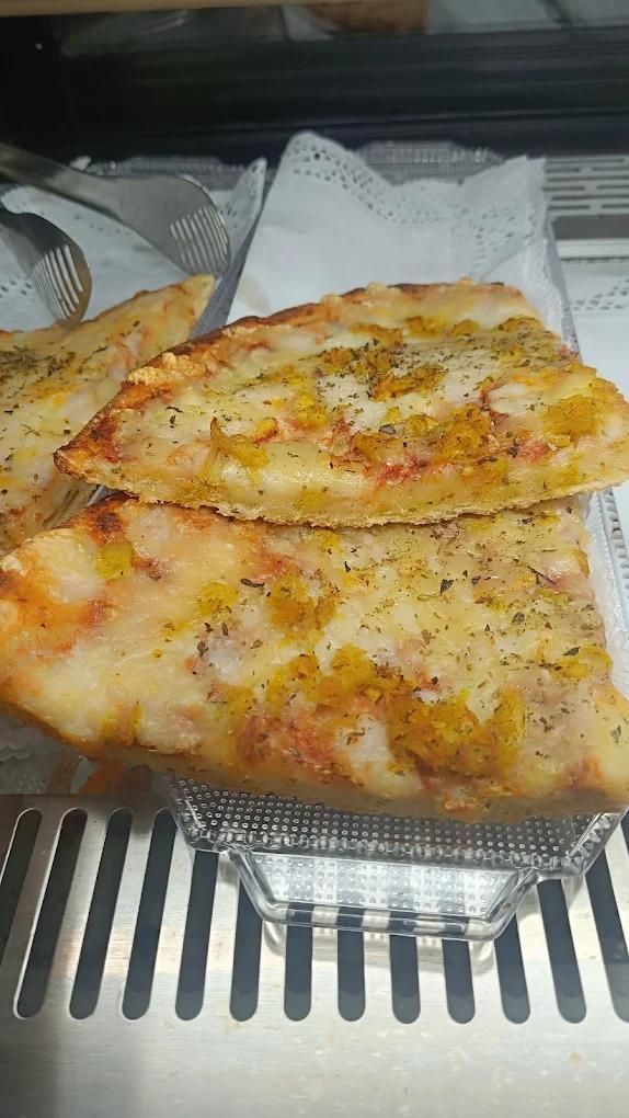 Dos rebanadas de pan horneado con queso en una bandeja de aluminio con una servilleta debajo.