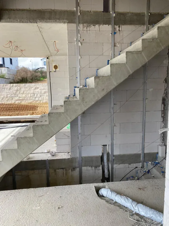 Betontreppe im Bau in einem Gebäude; graue, unfertige Wände und Treppen.