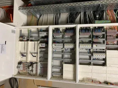 Schalttafel mit mehreren darin montierten Modulen, Kabeln und Komponenten.