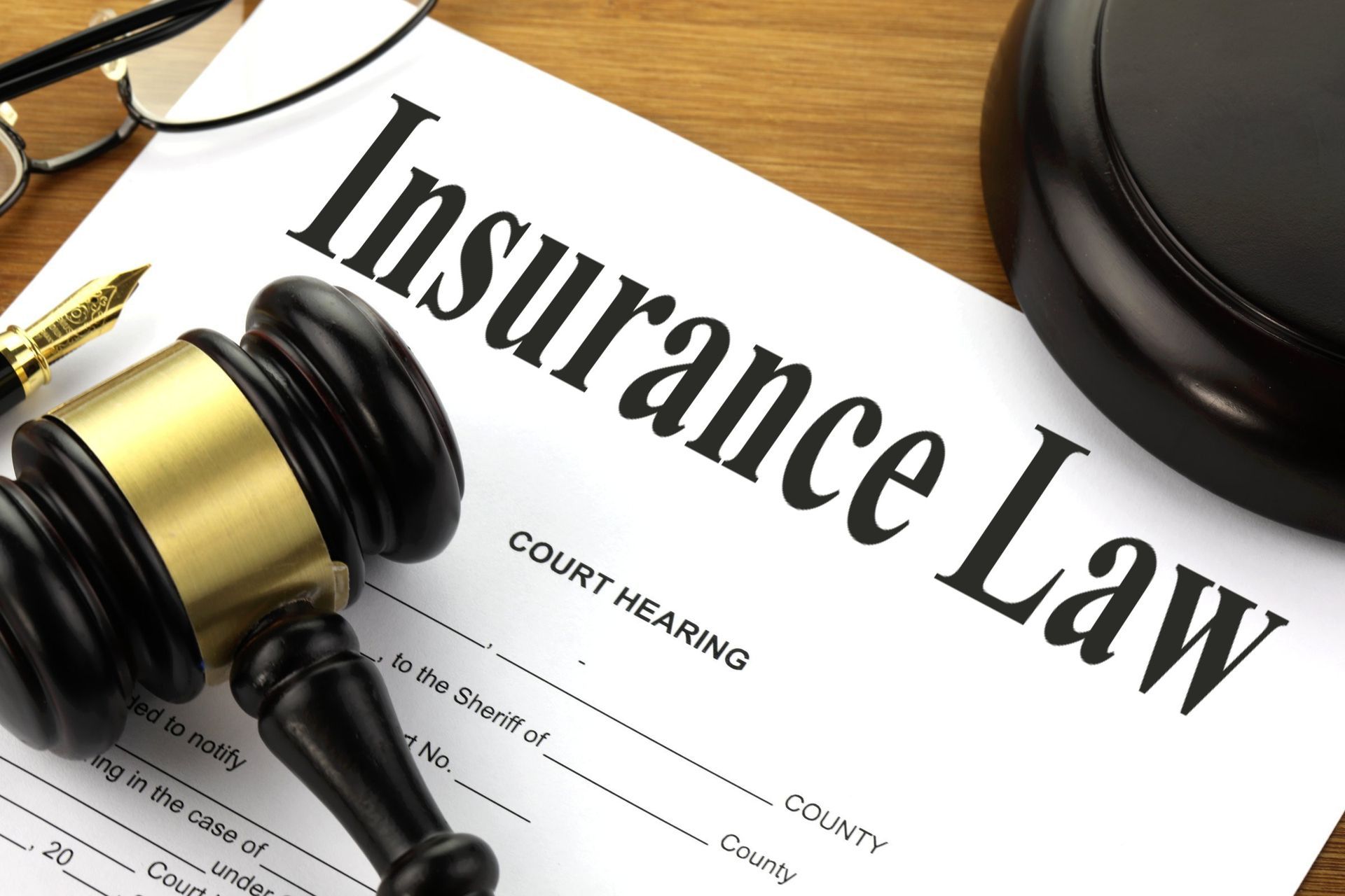 A judge 's gavel sits on top of an insurance law form