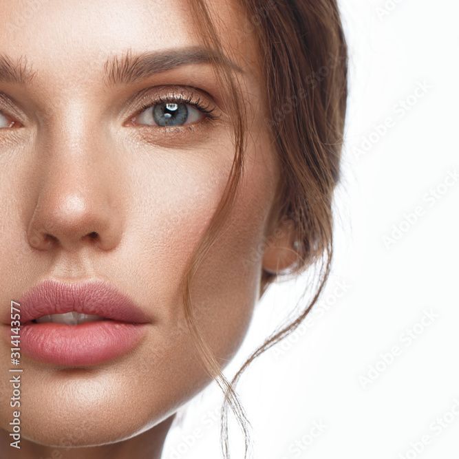 Eine Nahaufnahme des Gesichts einer Frau auf einem weißen Hintergrund.