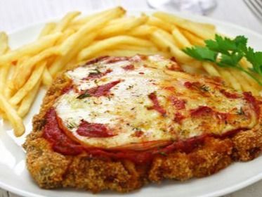 Pollo a la parmesana con patatas fritas en un plato blanco, cubierto con queso derretido y salsa roja.