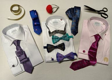 Tres camisas con pajaritas y tijeras sobre una mesa