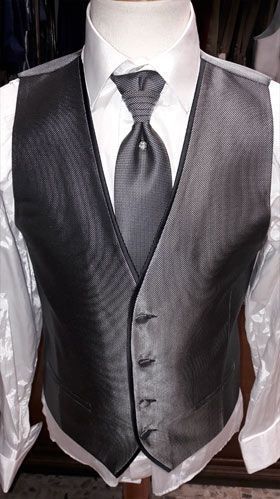 Un hombre lleva un chaleco gris y corbata sobre un maniquí.