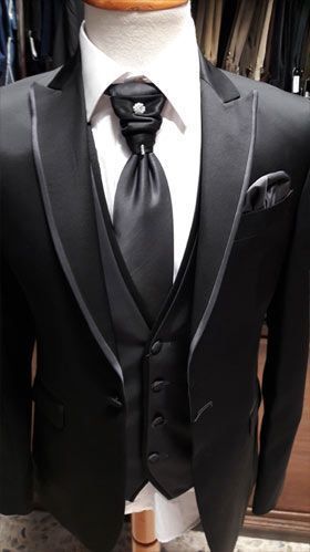 Un hombre lleva un esmoquin negro y corbata sobre un maniquí.