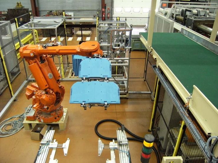 Bras robotique articulé orange d'un automate fonctionnant dans un atelier.