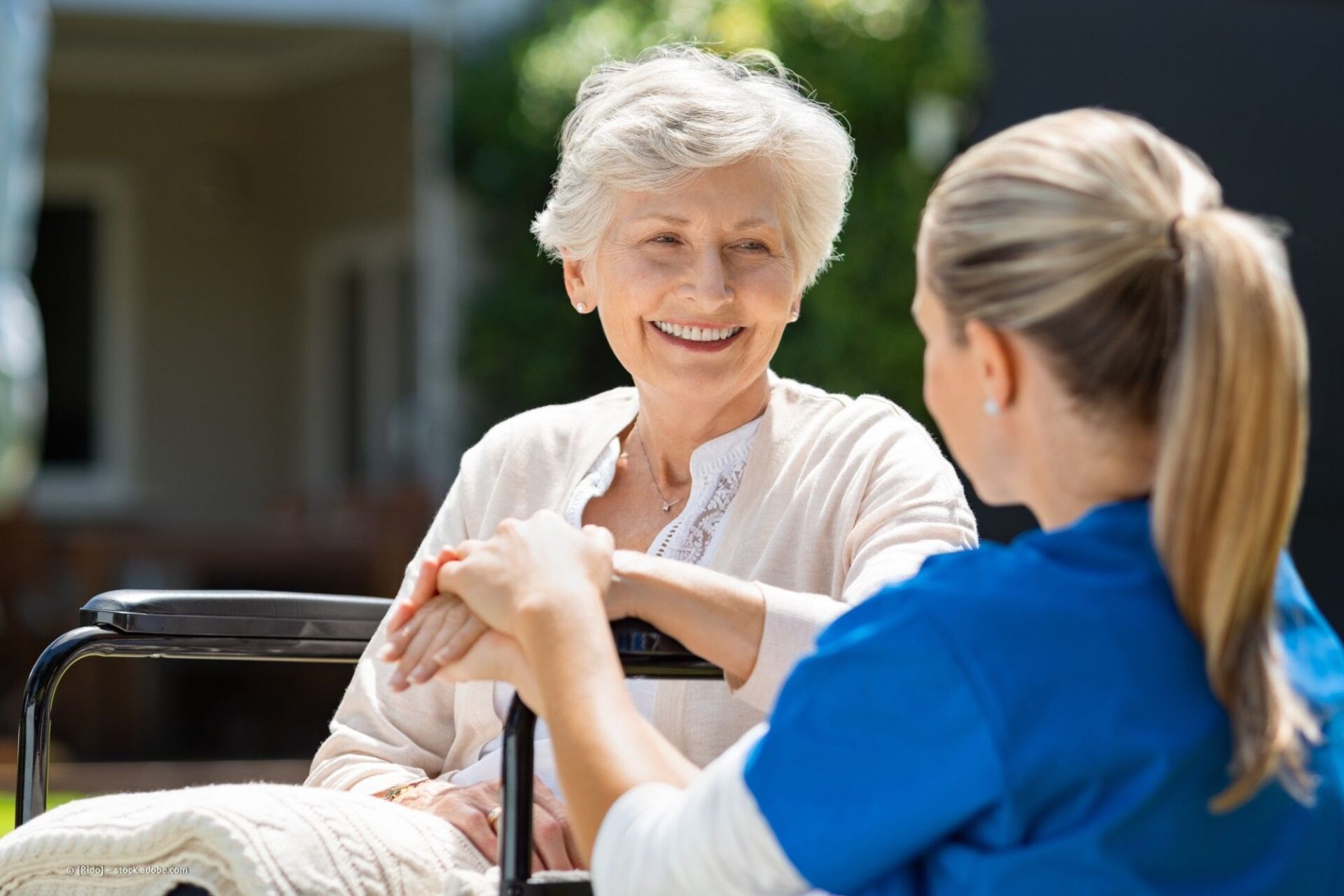 Junge Frau unterhält sich mit alter Frau auf einer Bank