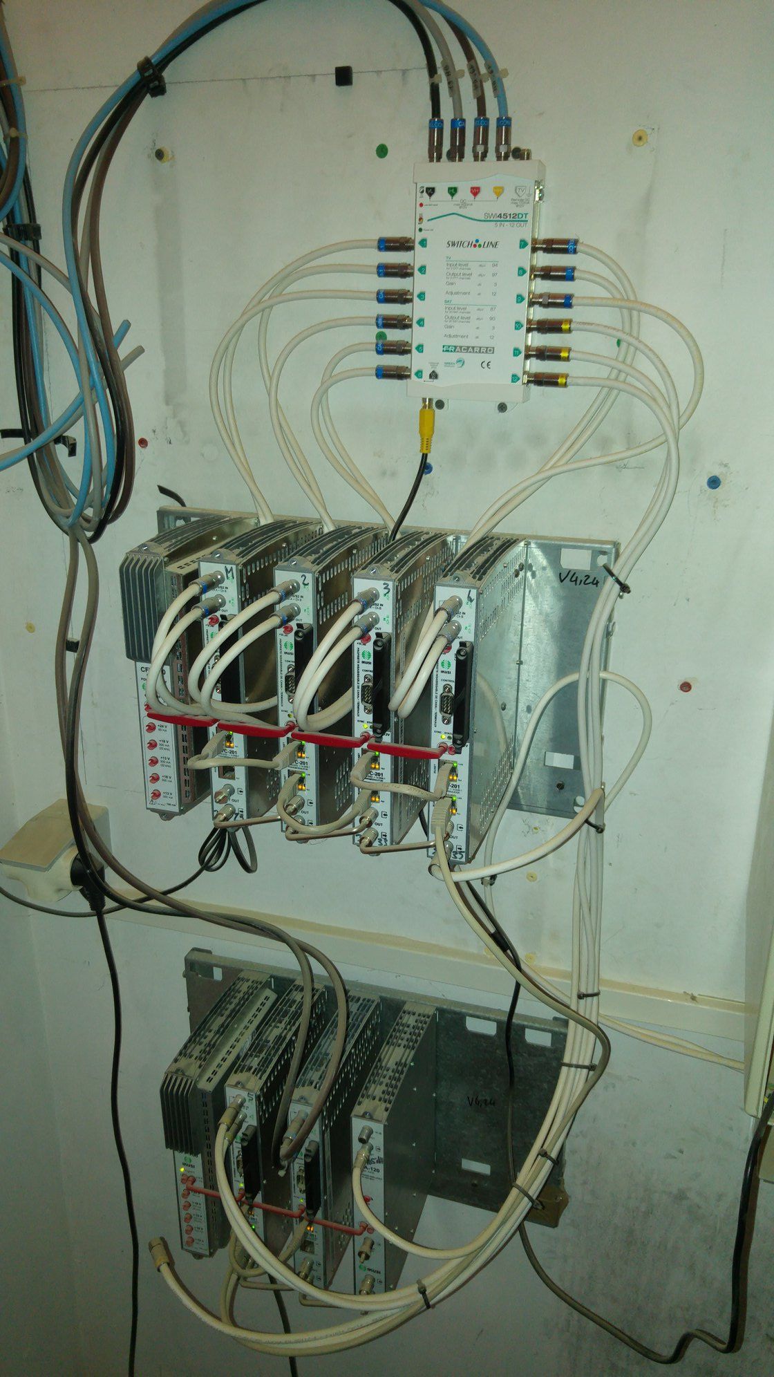 Équipement réseau monté sur un mur avec divers câbles et connecteurs.