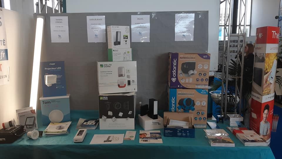 Une table d'affichage avec des appareils électroniques dessus, devant un tableau d'affichage.