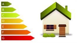 Ein Haus mit Gründach neben einem Energieeffizienzdiagramm.
