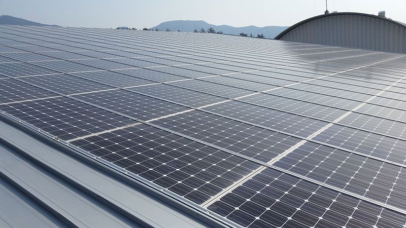 Auf dem Dach eines Gebäudes befinden sich viele Solarmodule.