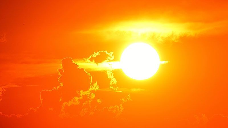 Die Sonne scheint hell durch die Wolken bei Sonnenuntergang