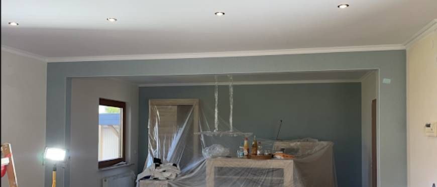 Ein frisch gestrichenes Wohnzimmer, professionell abgedeckte Möbel.