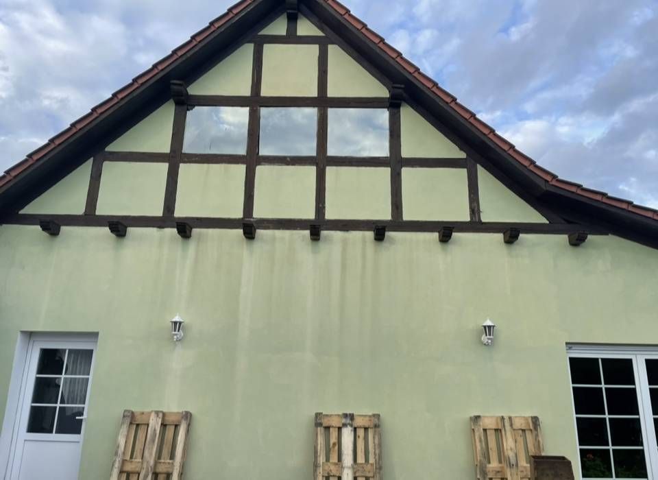 Ein grünes Gebäude mit einem dreieckigen Dach.