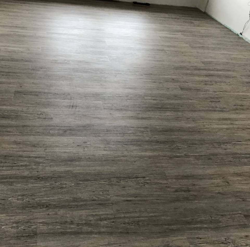 Ein Raum mit Holzboden und weißer Wand.