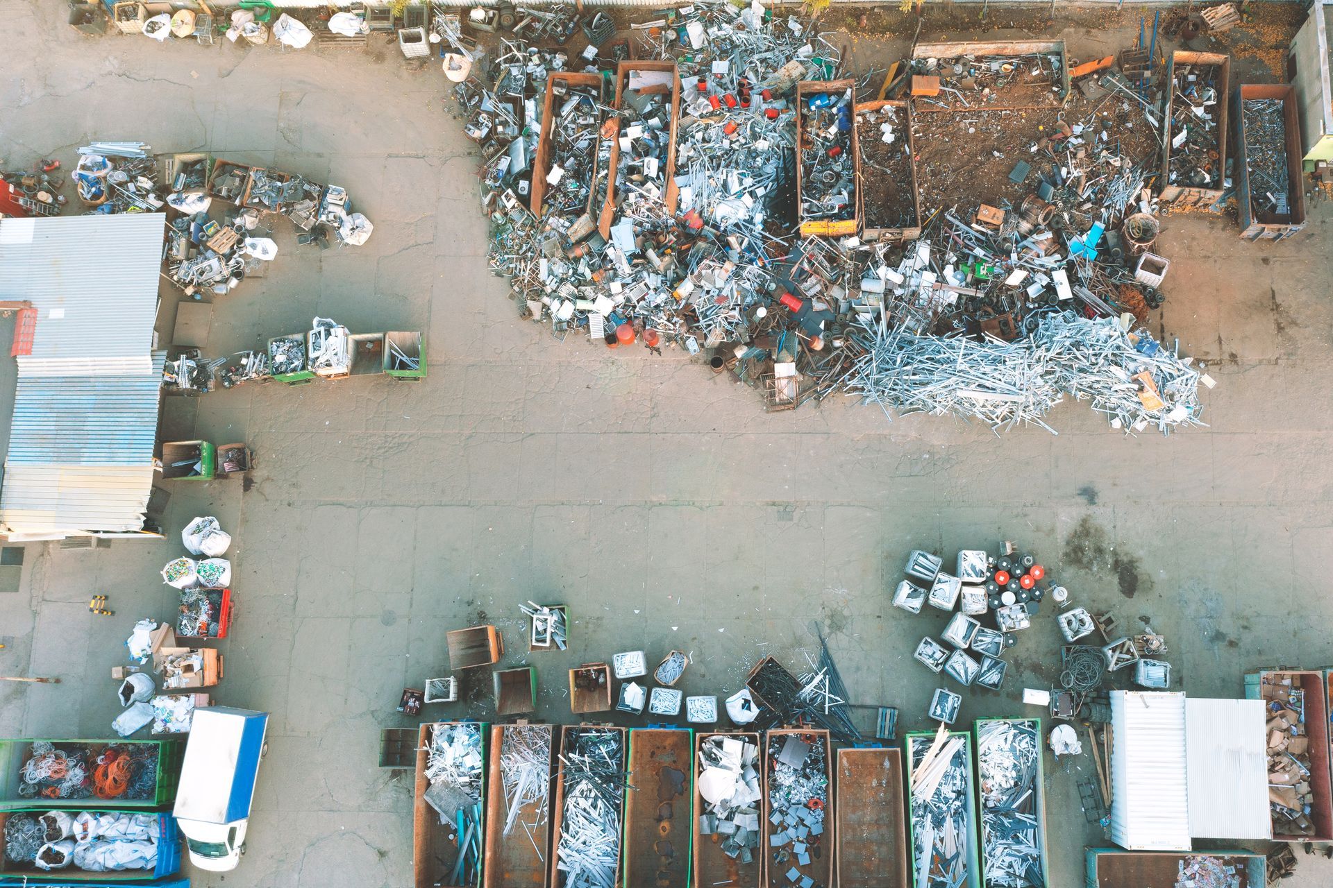 Vue aérienne d'un centre de recyclage avec des tas de ferraille, de déchets et de conteneurs pour le tri.