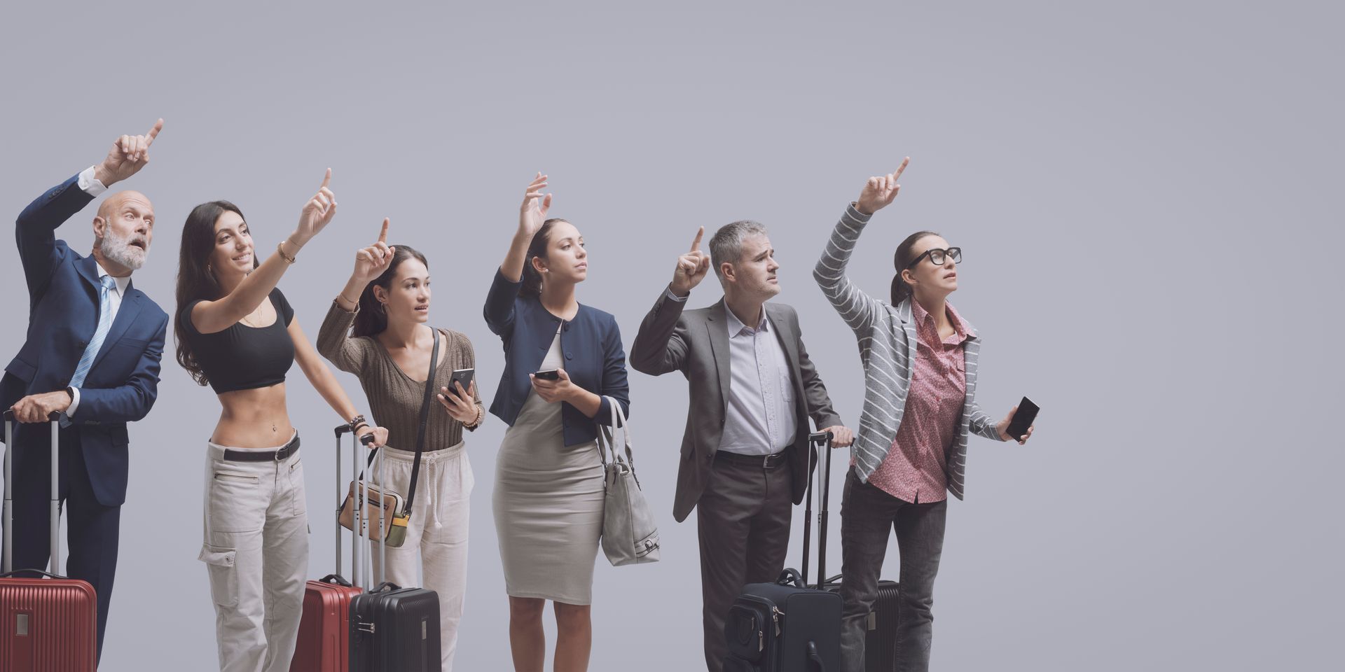 Groupe de personnes avec des bagages pointant vers le haut. Fond gris.