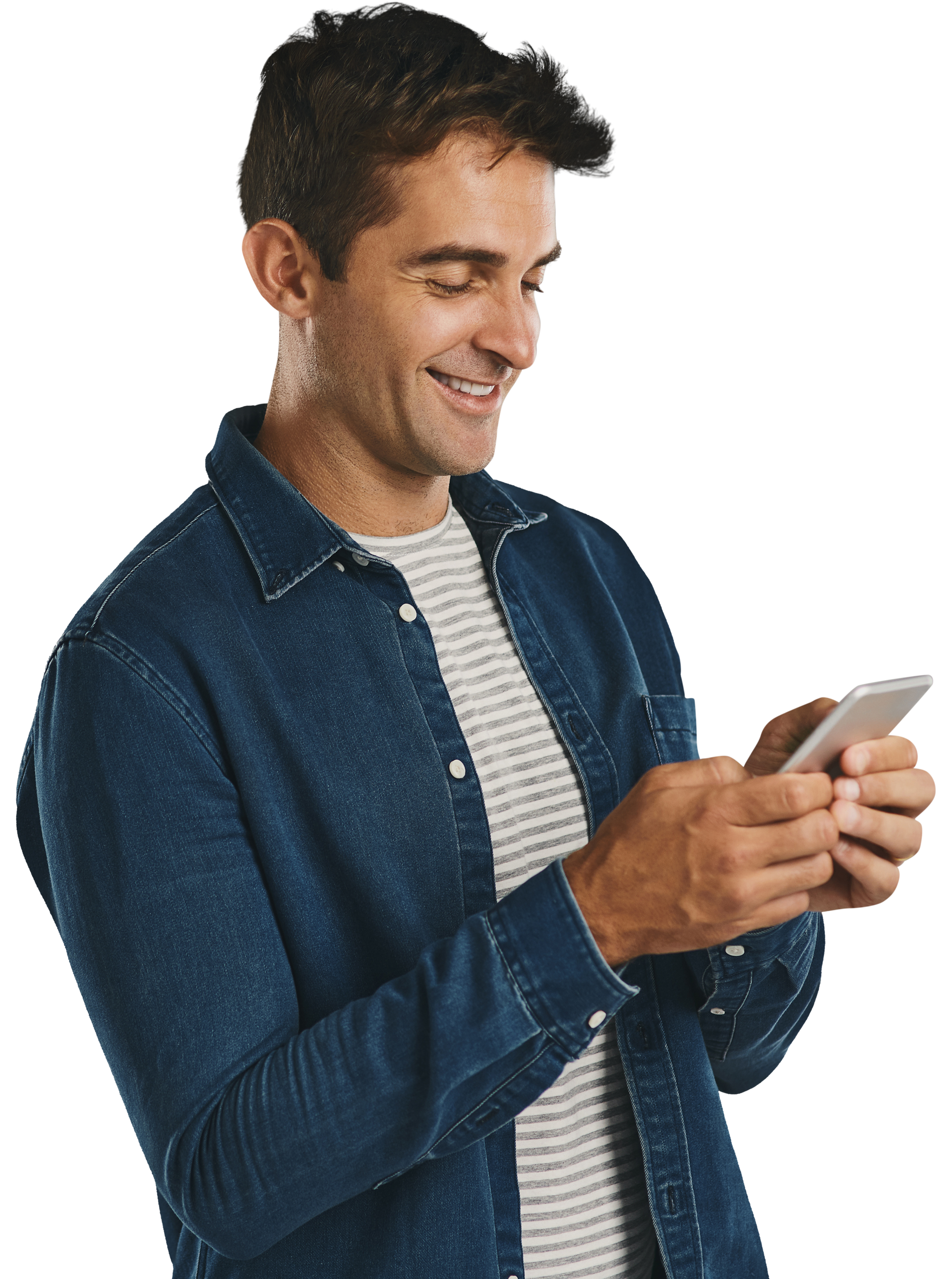 Un homme sourit en regardant son smartphone. Il porte une veste en jean bleue et une chemise à rayures.