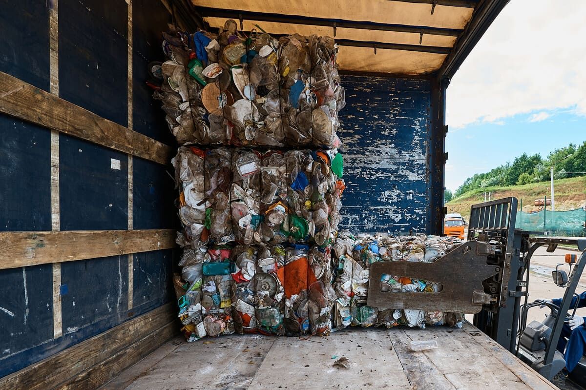 Fardos de botellas de plástico comprimidas en el cajón de un camión, listas para reciclar.