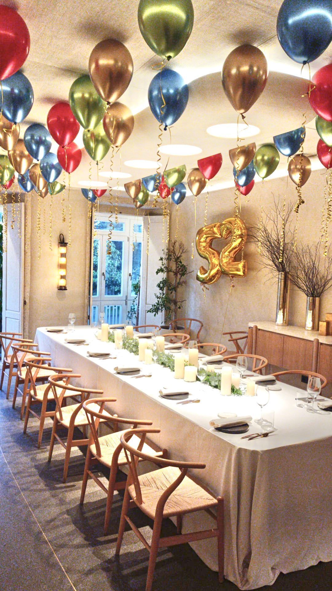 Un montón de globos con un arcoíris y el número 2 en él.