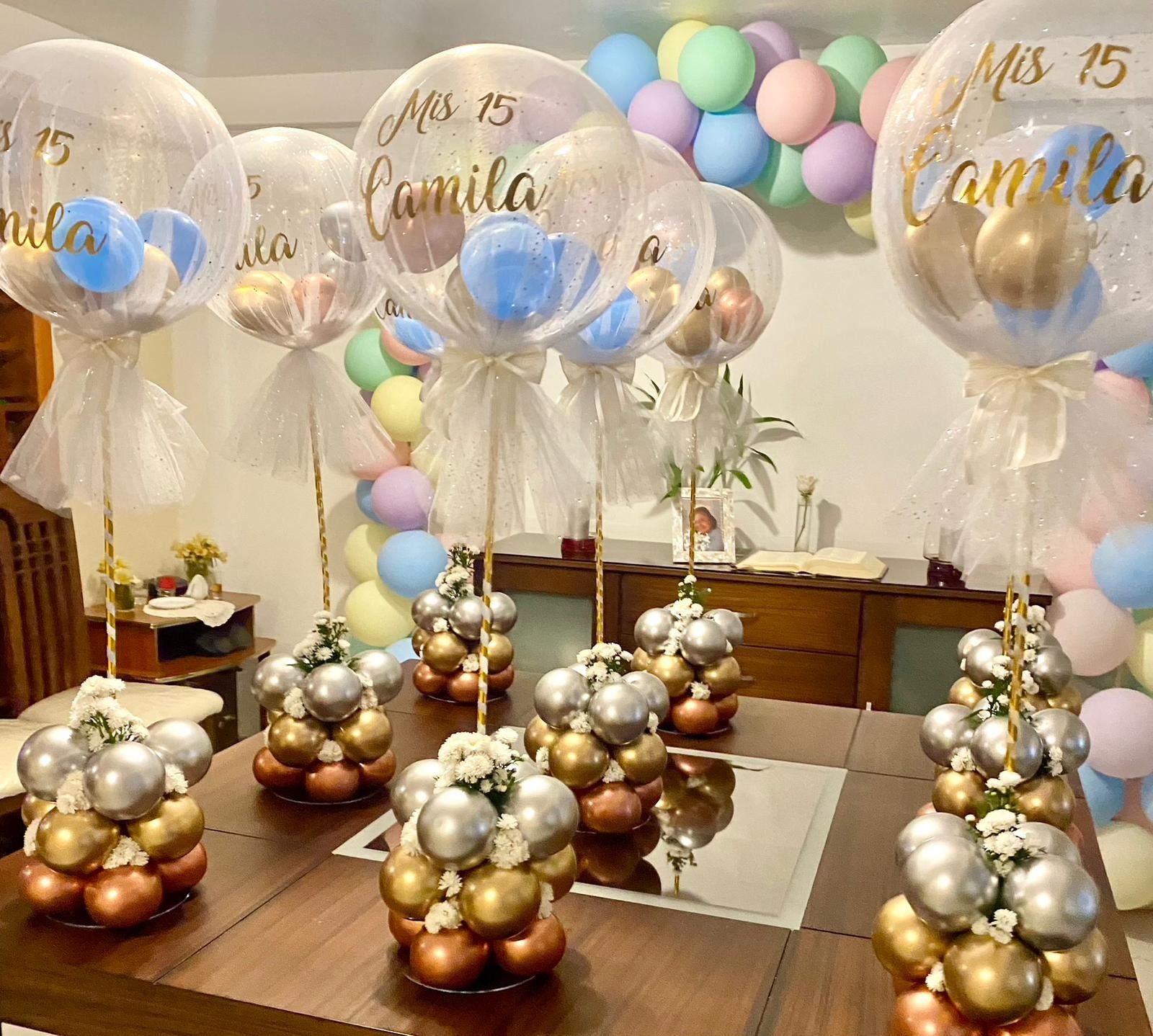 Una mesa está decorada con globos y flores para una fiesta.
