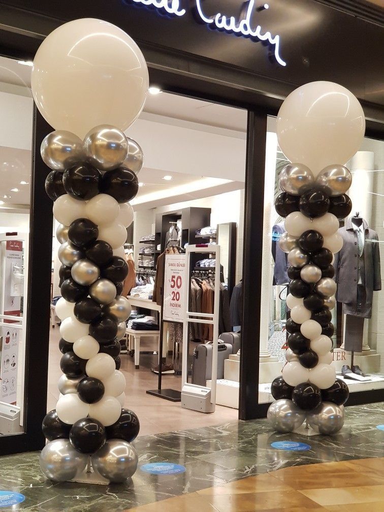 Un escaparate decorado con globos blancos y negros.