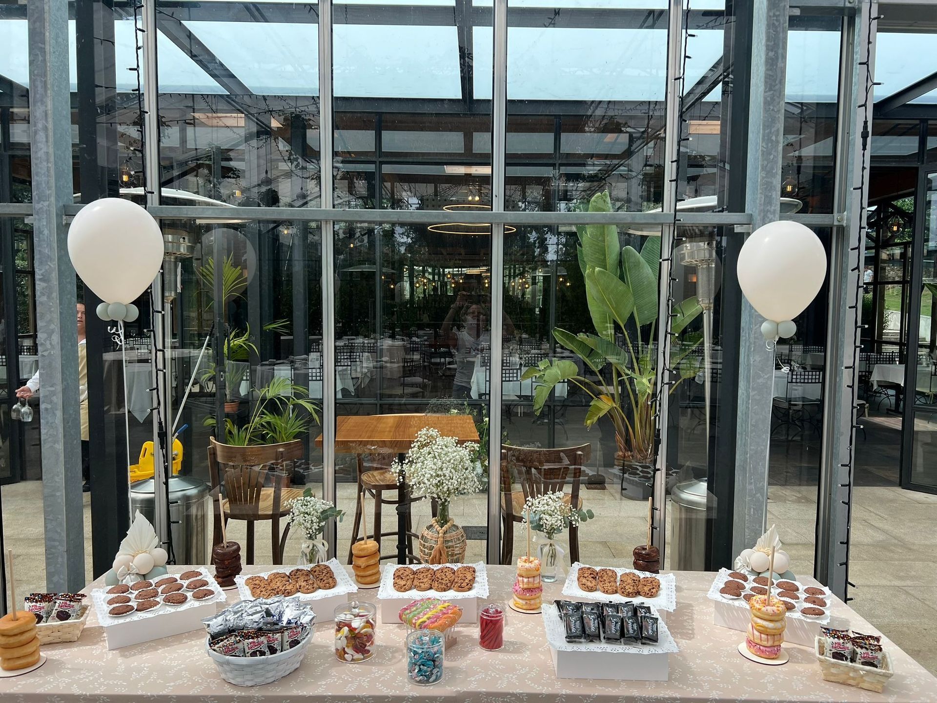 Una mesa con una variedad de postres y globos sobre ella.